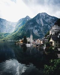 Buildings by sea against mountains and sky