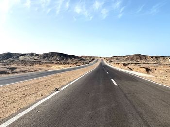 Road passing through landscape against sky