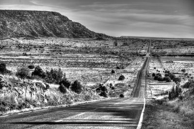 Road amidst field against sky