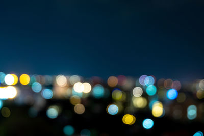 Defocused image of illuminated lights in city at night