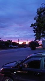 Cars on road against cloudy sky