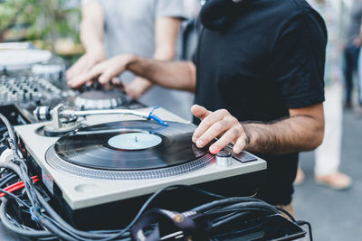 Midsection of men mixing music at concert