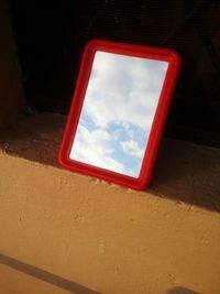 Red mirror against sky