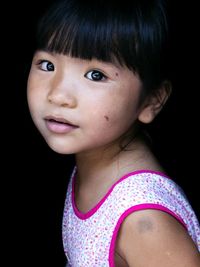 Close-up portrait of girl with bangs against black background