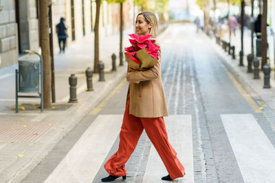 Portrait of young woman standing on street in city