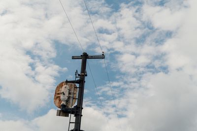 Low angle view of telephone pole against sky