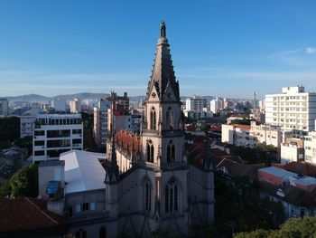 Buildings in city against blue sky