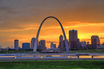 Modern buildings in city against sky during sunset