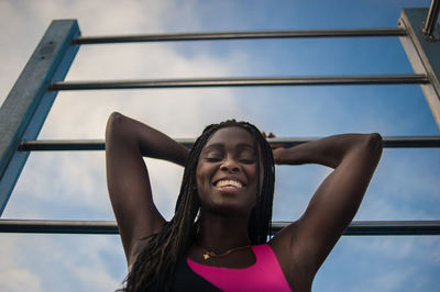 Low angle portrait of woman against sky