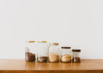 Glass of jar on table against white background