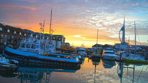 Boats in harbor at sunset