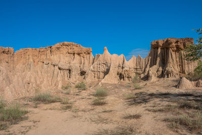 Panoramic view of arid landscape against clear blue sky