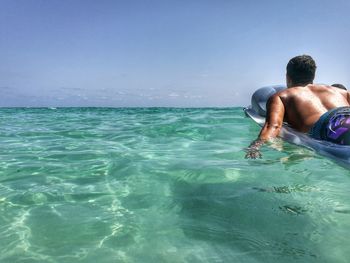 Man surfing in sea against sky