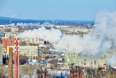 High angle view of smoke emitting from city against sky