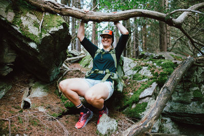 Portrait of a smiling young woman sitting in forest