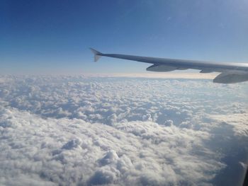 Cropped image of airplane flying over clouds