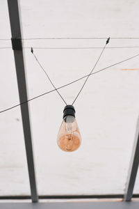 Low angle view of light bulb hanging from ceiling