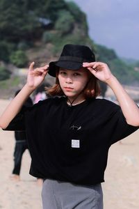 Portrait of young woman standing at beach