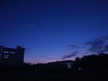 Low angle view of silhouette buildings against sky at night