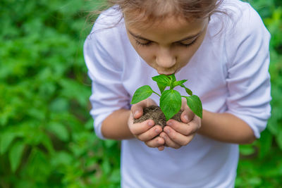 Girl kissing leaf of plant