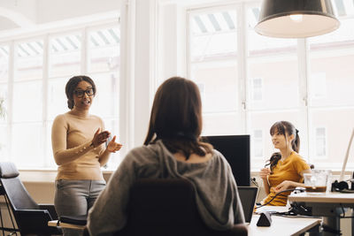 Female computer hackers discussing in creative office