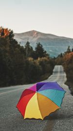 Multi colored umbrella on road against mountains