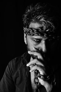 Portrait of young man against black background