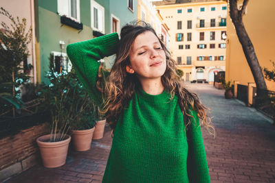 Portrait of woman standing against building