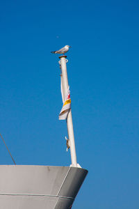 Low angle view of ship against clear blue sky