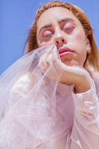 Close-up portrait of young woman against gray background