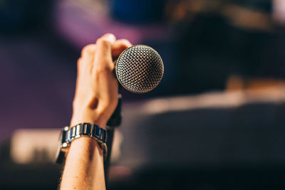 Cropped hand of musician holding microphone