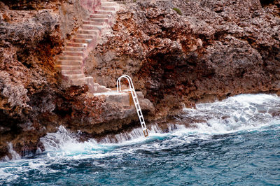 Water flowing through rocks by sea