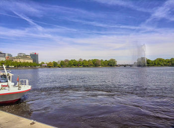 Scenic view of river against sky in city