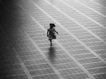 High angle view of girl running on footpath in city