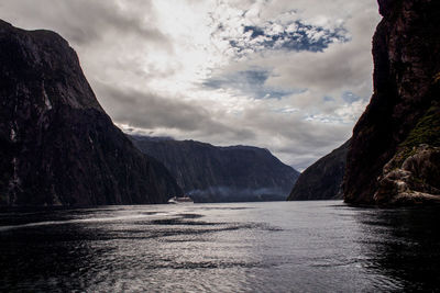 Scenic view of river by mountains against sky