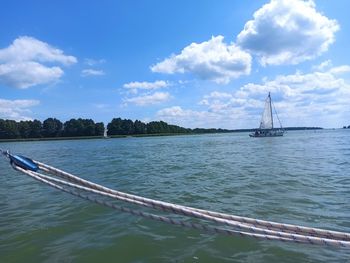 Sailboat sailing on sea against sky