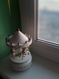 Close-up of electric lamp on window sill