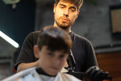 Hairdresser cutting child haircut