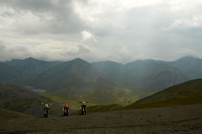 People on mountain range against sky