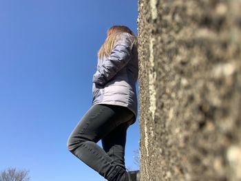 Low section of woman against clear blue sky