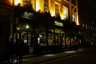 Illuminated city street at night