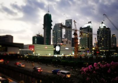 Cars on road in city against sky