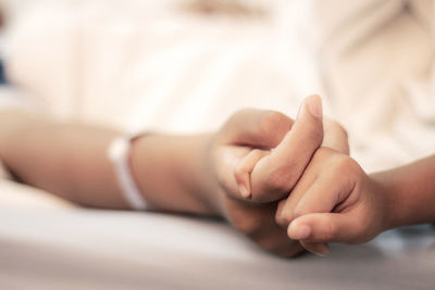 Cropped image of mother and child with holding hands