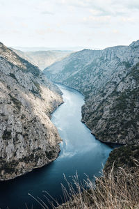 High angle view of river amidst mountains against sky