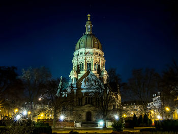 Statue of illuminated cathedral at night