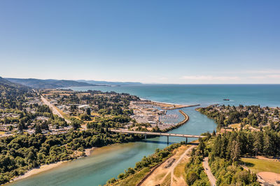 High angle view of city by sea against clear sky