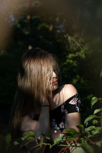 Close-up of young woman standing amidst plants