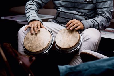 Midsection of man playing drum