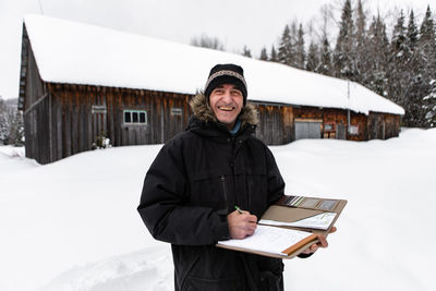 Portrait of smiling man standing in snow