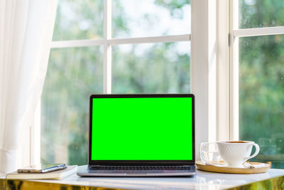 Coffee cup on table against window
